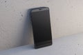 Close up of empty black mock up smart phone on light wall background. Mobile app concept.