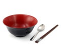 black and red plastic bowl with stainless steel spoon and brown wooden chopsticks isolated on white background