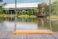 Close up empty chain swings in playground with lake and green trees in the background. Royalty Free Stock Photo