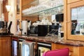 Close-up of empty coffee bar with coffee machine, microwave oven, glasses shelves wooden vintage counter