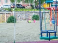 Close-up of empty colorful plastic baby swing on Playground in Park on summer day Royalty Free Stock Photo