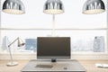 Close up of empty computer screen on wooden office desk top with objects, lamp and supplies on panoramic window and city view Royalty Free Stock Photo