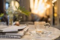 Close up of empty and drity glass cup of hot coffee with plate on table with newspaper in the living room