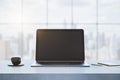 Close up of empty laptop computer on concrete desktop with coffee cup, notepad, pen, mock up place on screen, blurry office