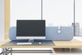 Close up of empty mock up computer monitor in modern bright coworking office interior with blue partition, panoramic windows with