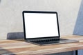 Close up of empty mock up laptop screen on wooden desktop and concrete wall background with shadow. Designer desktop and ad Royalty Free Stock Photo