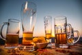 Close up empty mugs of beer on a sunrise background with mountains. Beer party is over concept. Royalty Free Stock Photo