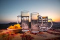 Close up empty mugs of beer on a sunrise background with mountains. Beer party is over concept. Royalty Free Stock Photo