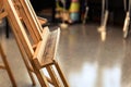 Close up of empty old stained wooden easel tripod for painting frame and canvas in the studio Royalty Free Stock Photo