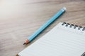 Close up empty open lined notebook and blue color pencil on wooden table background with copy space selective focus Royalty Free Stock Photo