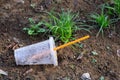 Close up of empty plastic cup on the grass ground. Plastic waste pollution concept Royalty Free Stock Photo