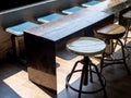 Close-up empty round swivel wooden chairs, stylish iron and wood long table and row waiting seat.
