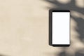 Close up of empty cellphone on light surface with leaf shadows. Presentation concept. Mock up, 3D Rendering Royalty Free Stock Photo