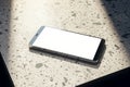 Close up of empty cellphone on spotted table. Mock up, 3D Rendering