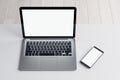 Close up of empty white laptop and cellphone on light desktop, mock up place on screen, wooden parquet flooring background. Top Royalty Free Stock Photo