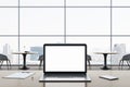 Close up of empty white laptop computer screen on wooden office desktop with supplies on panoramic window and city view background Royalty Free Stock Photo