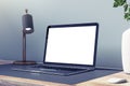 Close up of empty white laptop computer on wooden desk with decorative vase and plant, lamp and mock up place on concrete wall Royalty Free Stock Photo