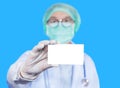 Close up empty white signboard blank paper card showing in hand surgeon wearing surgical face mask