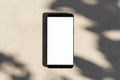 Close up of empty smartphone on light surface with leaf shadows. Presentation concept. Mock up, 3D Rendering Royalty Free Stock Photo