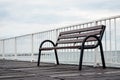 Empty  wood sitting  bench on a  pontoon bridge      at seashore.  Concept of loneliness and contemplation Royalty Free Stock Photo