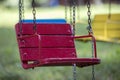 Close-up of empty wooden blue, yellow, vintage seats of multi-colored carousel hanging on chains Royalty Free Stock Photo