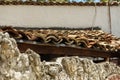 A close up end view of an old ceramic clay tile over a clay wall of a fence. Old roof tile of a poor dilapidated village house as Royalty Free Stock Photo