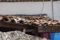 A close up end view of an old ceramic clay tile over a clay wall of a fence. Old roof tile of a poor dilapidated village house as Royalty Free Stock Photo