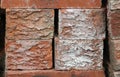 Close-up of ends of four red bricks in a pile