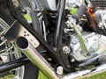 Close up of the engine and chrome exhaust pipe of a vintages custom 1970s scrambler type motorcycle