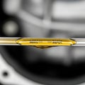 A close-up of an engine oil dipstick with clear markings for \