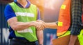 Close up of engineer and foreman worker handshake with blurred construction site, Success and Teamwork concept Royalty Free Stock Photo