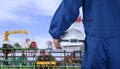 Engineer hand holding white safety helmet before working on crude oil tanker in shipyard area Royalty Free Stock Photo