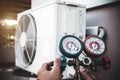 Close-up engineer using measuring manifold gauge for filling industrial air conditioner after cleaner and checking for maintenance Royalty Free Stock Photo