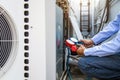 Close-up engineer using measuring manifold gauge for filling industrial air conditioner after cleaner and checking for maintenance Royalty Free Stock Photo