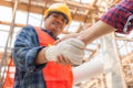 Close up of engineer and worker handshake with blurred construction site, Success and Teamwork concept Royalty Free Stock Photo