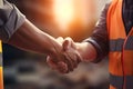 Close up of engineer and worker shaking hands on construction site background - Ai Generated Royalty Free Stock Photo