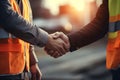 Close up of engineer and worker shaking hands on construction site background - Ai Generated