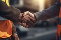 Close up of engineer and worker shaking hands on construction site background - Ai Generated Royalty Free Stock Photo