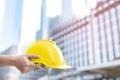 Close up of engineering male construction worker hand holding give safety yellow helmet  for the safety of the work operation. Royalty Free Stock Photo