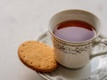 Close up of English tea in a porcelain china cup with a digestive biscuit Royalty Free Stock Photo