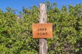 Close up of an engraved wooden Anns Point sign against green leaves and blue sky Royalty Free Stock Photo