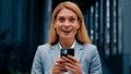 Close-up enthusiastic happy businesswoman receiving notification reading good news on telephone surprised excited woman