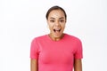 Close up of enthusiastic young woman, looking surprised and amazed, impressed reaction, standing over white background Royalty Free Stock Photo