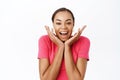 Close up of enthusiastic young woman, looking surprised and amazed, impressed reaction, standing over white background Royalty Free Stock Photo