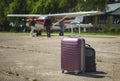 Close-up of equipment on the runway, aircraft in the background out of focus, passengers