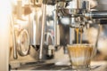 Close up of espresso pouring from automatic coffee machine to two milk shot glass in the restaurant Royalty Free Stock Photo