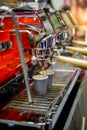 Close-up of espresso pouring from modern red coffee machine. Royalty Free Stock Photo
