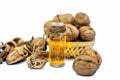 Close up of essential oil or essence of walnut or akhrot isolated on white in a small transparent glass bottle along with raw in s Royalty Free Stock Photo