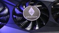 Close up of Ethereum coin on a black video card iilluminated by blue light. Ethereum mining concept