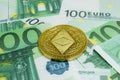 Close-up of Ethereum coins on 100 Euro banknotes. Crypto currency ETC